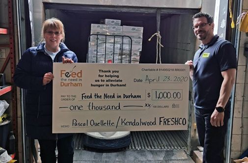 Freshco employee holding $1000 cheque for Feed the Need in Durham